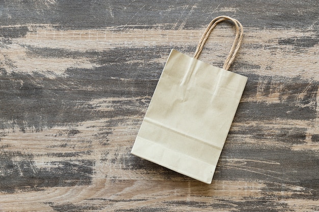 Recycled paper bag on old wood background, Eco friendly and sustainability concept