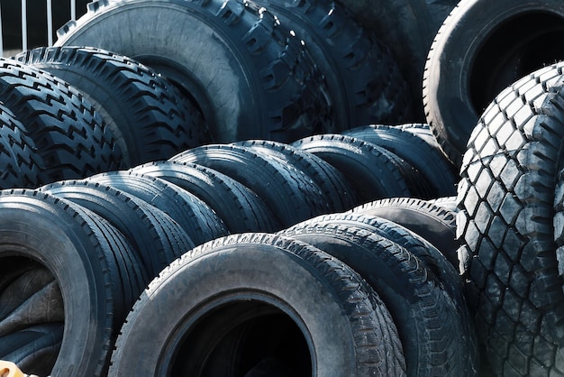 Recycling of car tires for trucks That39s a lot of black bald rubber tires lying outside in an open warehouse