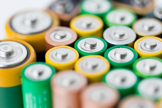 recycling, energy, power, environment and ecology concept - close up of alkaline batteries heap