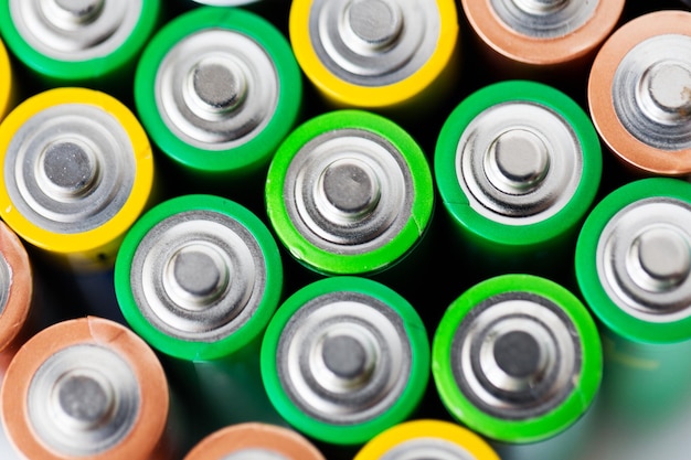 recycling, energy, power, environment and ecology concept - close up of alkaline batteries heap