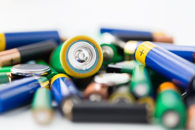 recycling, energy, power, environment and ecology concept - close up of alkaline batteries heap