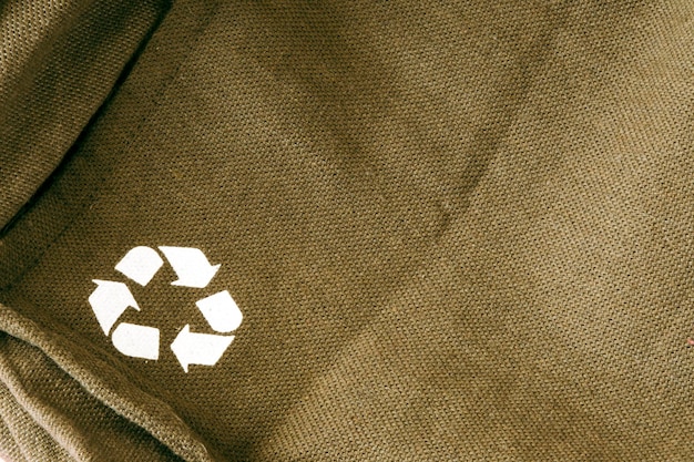 Recycling icon on green fabric.