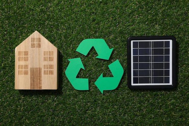 Recycling sign with solar panel on grass