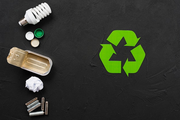 Recycling symbol beside various refuse