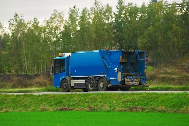 A recycling truck collects garbage bins on a suburban road The vehicle provides a valuable service for the environment and city Ecological and save the earth concept Trash and garbage separation