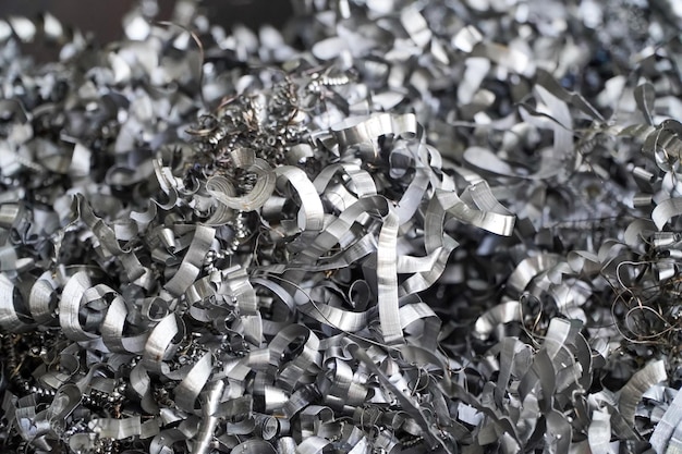 Recycling van staalschrootmaterialen Aluminiumchipafval na het machinaal bewerken van metalen onderdelen op een cnc-draaibank Close-up gedraaide spiraalvormige stalen spaanders Kleine ruwheid, scherpte