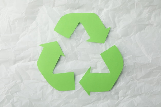 Recyclingsteken op witte verfrommelde document achtergrond, hoogste mening