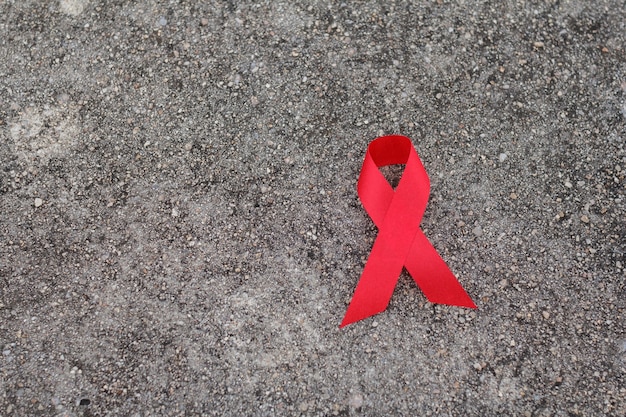 Foto nastro rosso di sensibilizzazione sull'aids. giornata mondiale contro l'aids e concetto di assistenza sanitaria e medicina