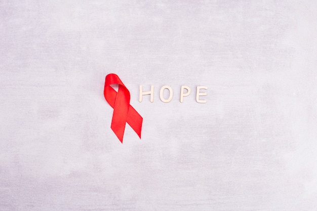 Red AIDS ribbon on a gray