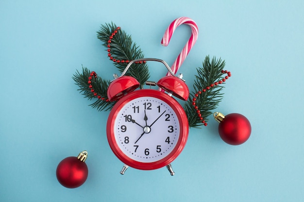 Red alarm clock and christmas composition on the blue background.Top view.Copy space.