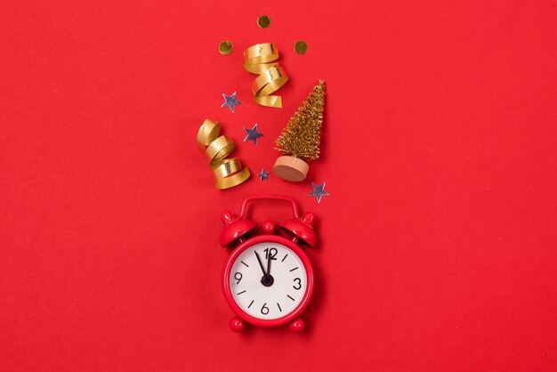 Red Alarm Clock and Christmas Gold Toys and Tree Top View Red Background Horizontal