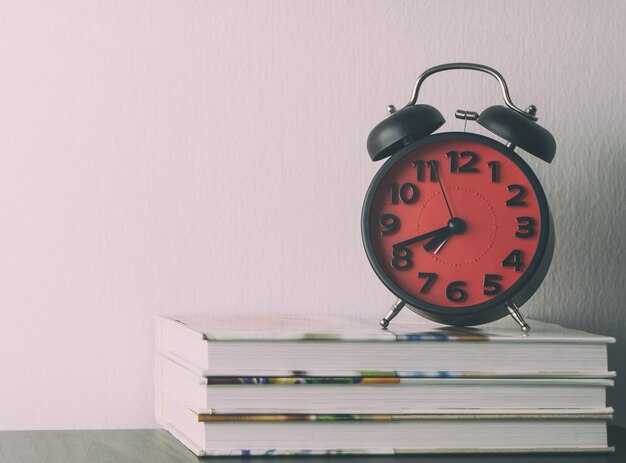 Photo red alarm clock on office table