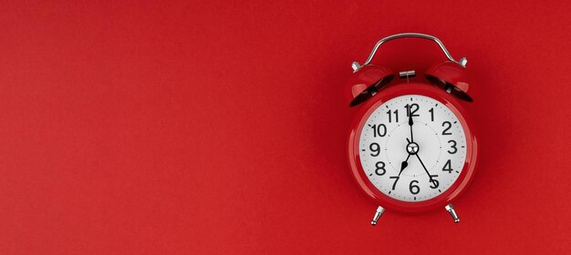 Photo red alarm clock on a red background top view