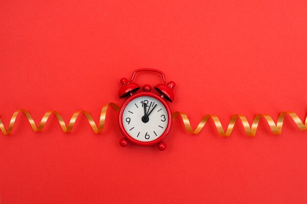 Red alarm clock on red background