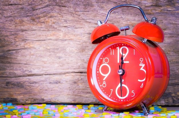 Red alarm clock on the wood background