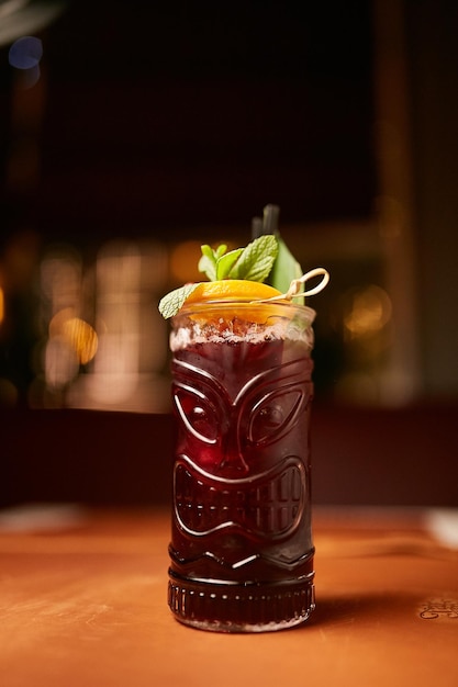 red alcohol cocktail with a slice of lemon on a bokeh background