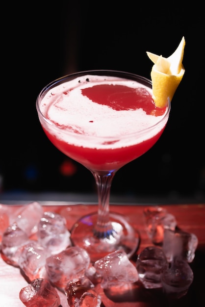 Red alcoholic cocktail on the bar decorated with lemon and ice
the bartender prepares drinks for guests night life club life great
serving of cocktails amazing cocktails