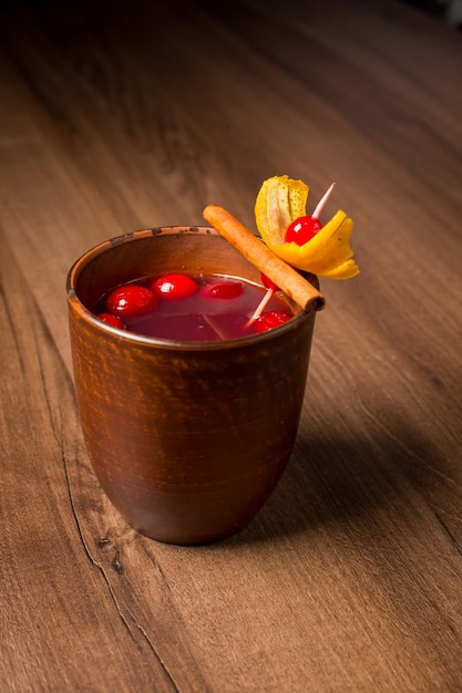 red alcoholic cocktail in a clay glass closeup on a wooden bar counter