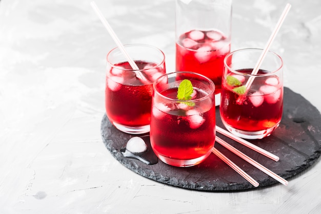 Красный алкогольный коктейль со льдом и мятой