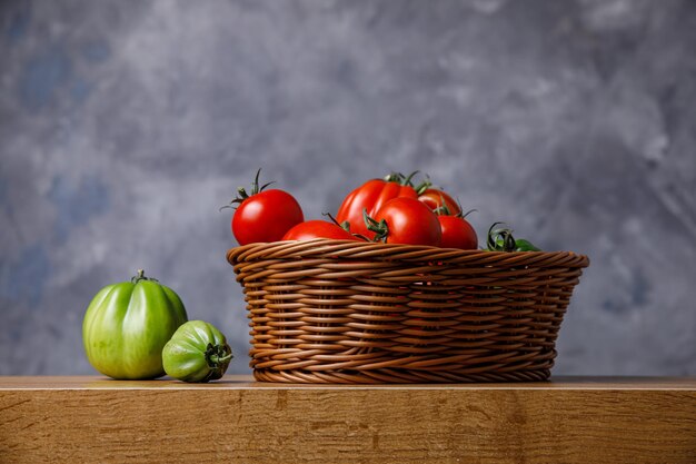 사진 젖은 배경에 바구니에 빨간색과 녹색 토마토