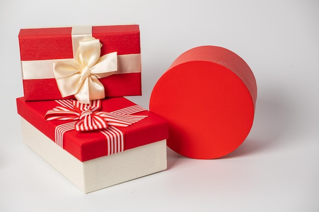 Фото Красные и полосатые коробки с подарками, завязанными бантиками на белом фоне