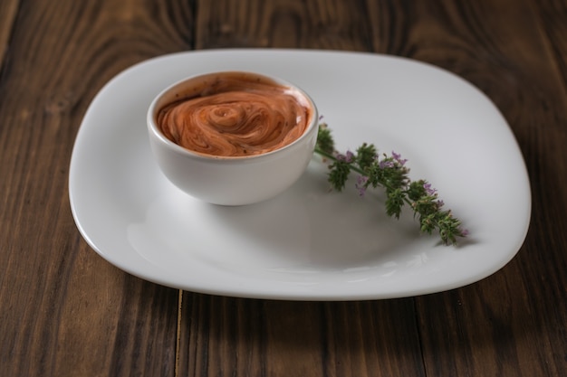 Фото Красный и белый острый соус с острой травой на белой тарелке. вегетарианский соус. соус к мясу и рыбе.