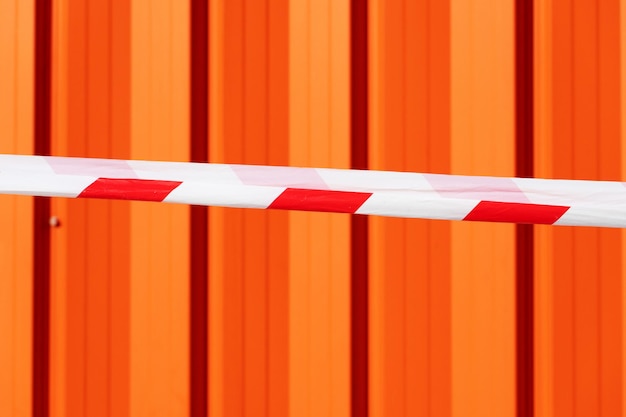 Фото Красно-белая предупреждающая лента на оранжевом фоне. предупреждение об опасности, небезопасной зоне. не входите.