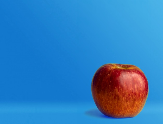 Photo red apple on a blue back