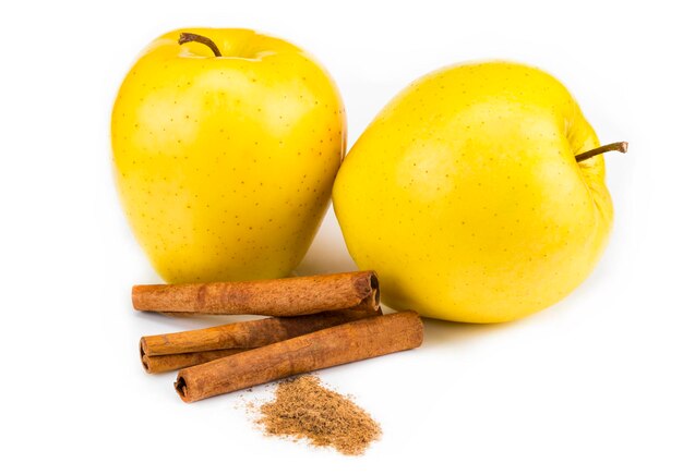 Red apple and cinnamon sticks isolated on white.