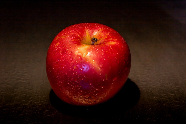 Red apple fruit in a low light