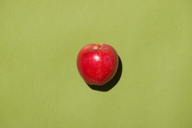 The red apple on green background.