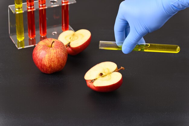 A red apple and laboratory glass with red liquid