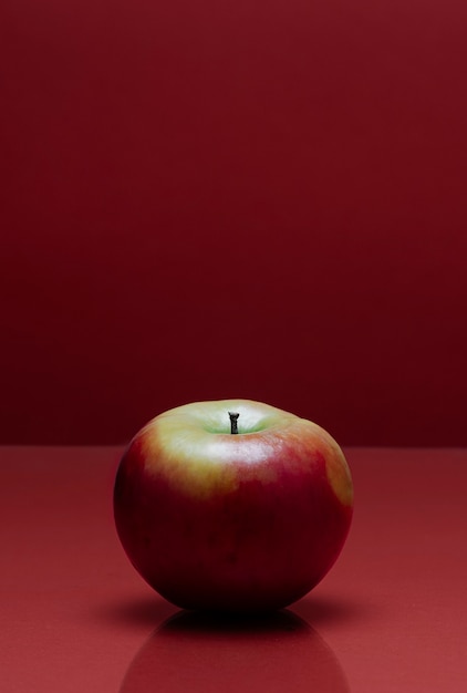 A red apple on a red table