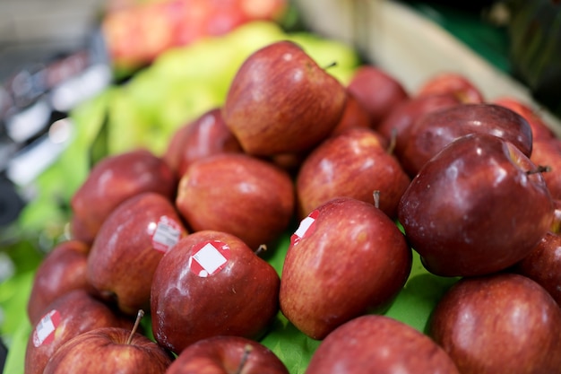 A red apple in a supermarket shelf is labeled.