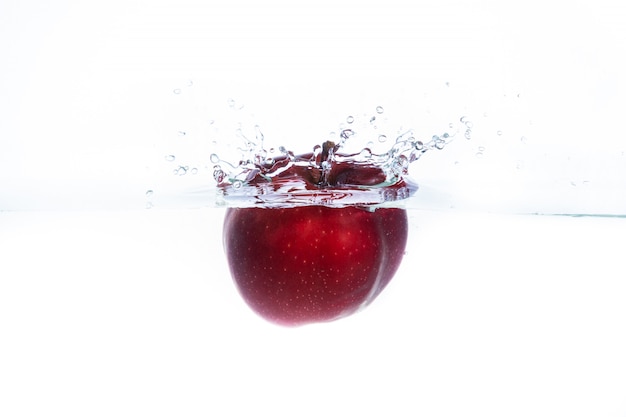 Красное яблоко брошено в воду