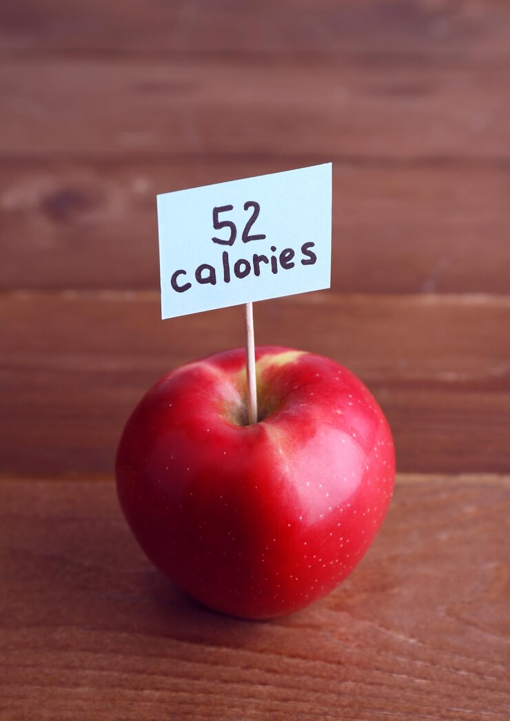 Photo red apple with calories count label on wooden table background