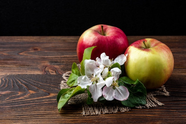 Red apple with flowers on table