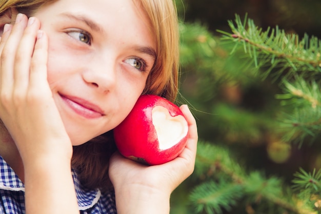 Red apple with heart shape - present of love. Focus on the fruit