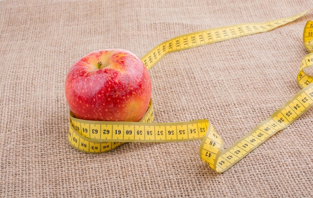 Red apple with a measurement tape on it