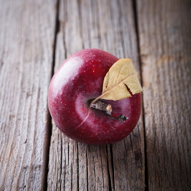 Красное яблоко на деревянном фоне