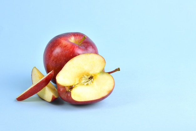 Red apples are arranged in such a way that they are both full and half split and are a popular fruit