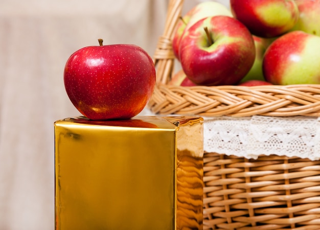 Red apples in a basket on a white wooden table