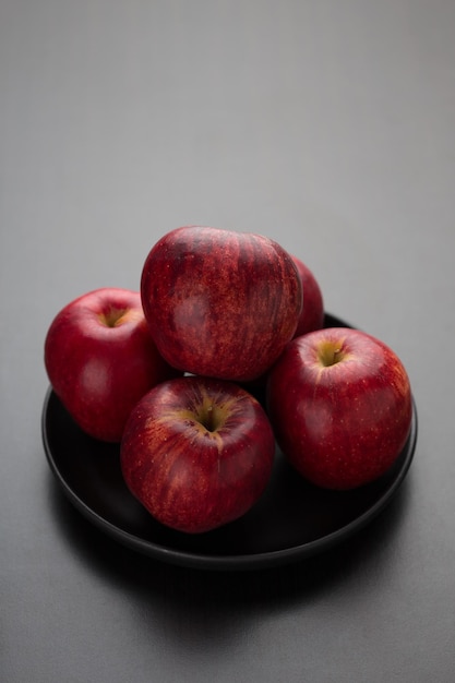 Red apples in a black plate