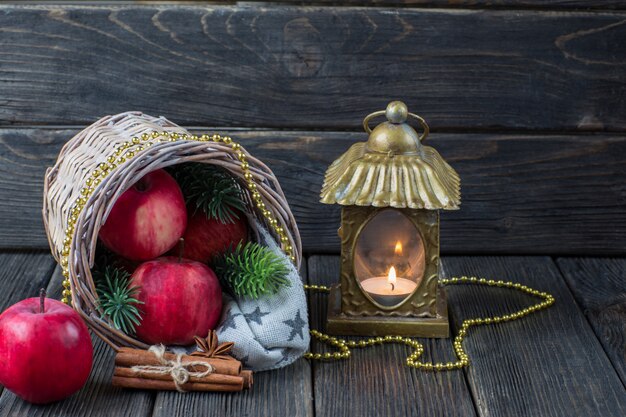 Red apples, branches of spruce, cinnamon, gold beads and an old candlestick