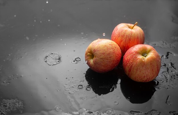 Red apples on a dark with raindrops