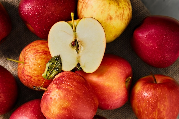 Red apples from a local farm in drops of water harvest season Layout on a gray table