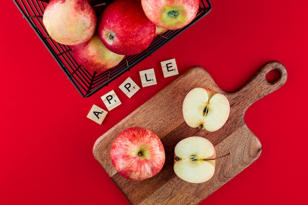 Red apples in the metallic black basket on the deep red . Top view flat lay composition.