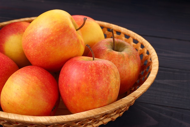 Red apples Pinova in a plate on a dark background