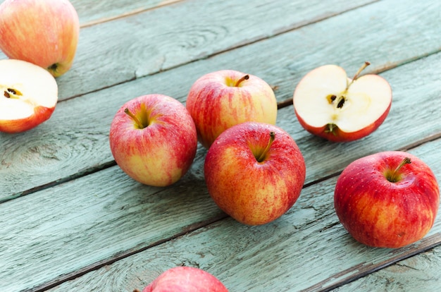 Red apples on turquoise wooden background. Autumn days.