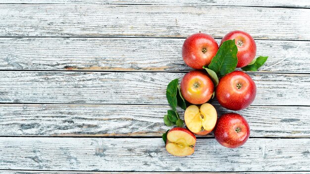 Red apples on a white wooden background. Fruits. Top view. Free space for text.